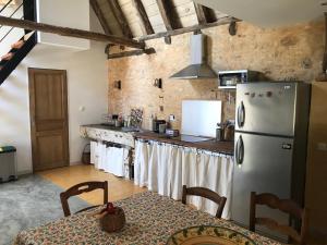 圣西普里安Gîte du Meynet的厨房配有白色冰箱和桌子