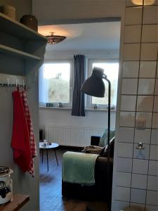 ein Wohnzimmer mit einem Sofa und einer Lampe in der Unterkunft Bij De Vuurtoren in Hollum