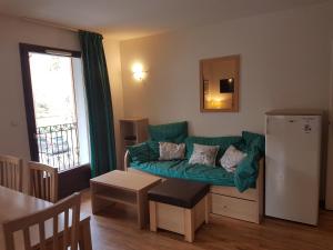 a living room with a green couch and a refrigerator at Bel Appartement 2 ch Les Jardins de Ramel in Luchon