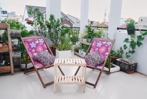 a pair of chairs on a balcony with plants at Căn Hộ 3 PN Rin's House in Phan Thiet