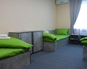 a room with two beds with green pillows at Green cost in Boryspilʼ