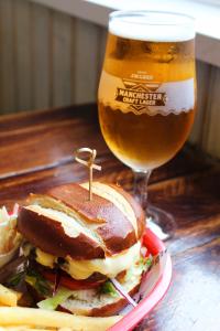 a sandwich and a glass of beer on a table at Black Lion Hotel in Manchester