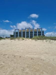 a building on the beach next to a sandy beach at Lindo Studio frente Mar Matinhos/PR. in Matinhos +13 photos