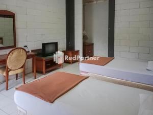 Katil atau katil-katil dalam bilik di Kampung Resort Pertiwi RedPartner
