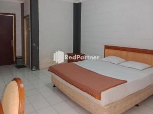 um quarto com uma cama num quarto em Kampung Resort Pertiwi RedPartner em Tagalbato