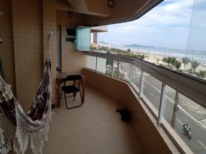 een balkon met een hangmat en uitzicht op het strand bij Frente pro mar apartamento completo in Praia Grande