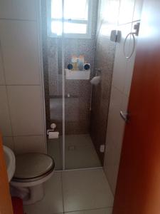 een badkamer met een douche, een toilet en een raam bij Frente pro mar apartamento completo in Praia Grande