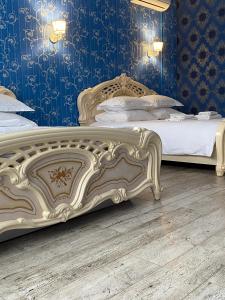 two beds in a bedroom with blue walls at Hotel Royal Poltava in Poltava +62 photos