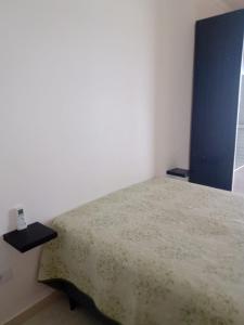 a small bedroom with a bed and a window at Frente pro mar apartamento completo in Praia Grande