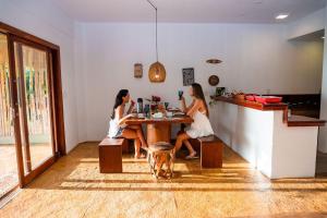 two women sitting at a table in a restaurant at Camocim Canoe House in Camocim