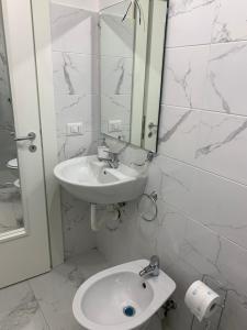 Un baño blanco con lavabo y espejo. en A cas e Nanninell, en Nápoles