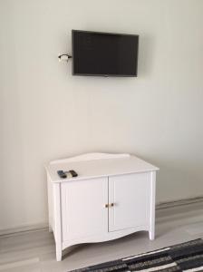 a white cabinet with a flat screen tv on a wall at Sailinn Mykonos in Ornos