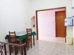 una sala da pranzo con tavolo, sedie e una porta di Pousada Fortaleza São Thomé a São Thomé das Letras