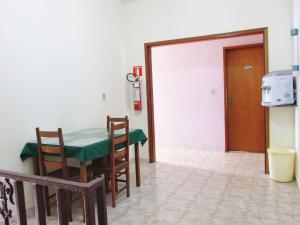 comedor con mesa, sillas y puerta en Pousada Fortaleza São Thomé, en São Thomé das Letras