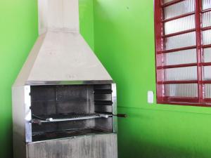 un horno de pizza en una sala verde con ventana en Pousada Fortaleza São Thomé, en São Thomé das Letras