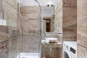 een badkamer met een douche en een wastafel bij Rainbow Apartments 1 Premium in Krakau