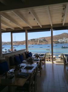a restaurant with tables and a view of the water at Sailinn Mykonos in Ornos