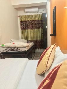 - une chambre avec 2 lits et une fenêtre avec un rideau dans l'établissement Bishnu Homestay, à Pokhara