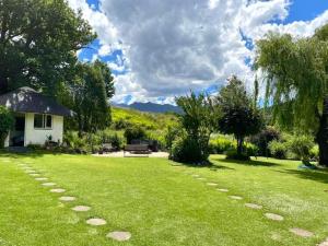 a grassy yard with a bench in the background at Esigodini Cottage in Underberg