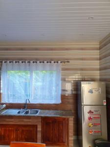 a kitchen with a refrigerator and a sink and a window at Coco De Mer Villa in Mahe