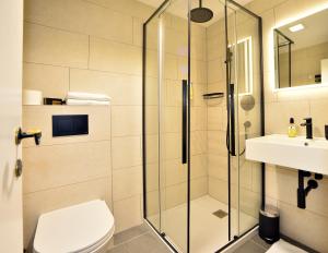 uma casa de banho com um chuveiro, um WC e um lavatório. em Hotel Christina em Seefeld no Tirol