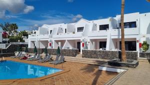 a large white building with a pool in front of it at Princesa Ico in Puerto del Carmen