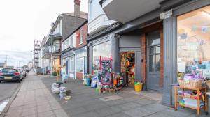a store on the side of a street next to a sidewalk at Tranquil Beachfront Beautiful 2-Bed Apartment in Deal