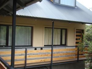 a house with a metal roof and a wooden fence at Apart LAR DEL PEHUEN in Villa Pehuenia