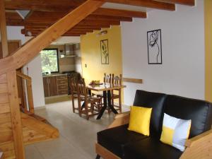 a living room with a couch and a dining room at Apart LAR DEL PEHUEN in Villa Pehuenia