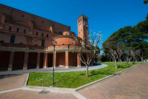 un grand bâtiment en briques avec une tour d'horloge dans l'établissement Casa La Salle - Roma Vaticano, à Rome