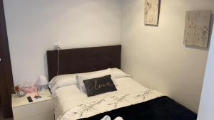 a small bedroom with a bed with a brown headboard at Pensión Residencia Fonseca in Santiago de Compostela