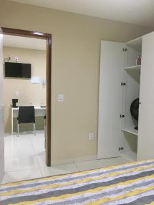Pokój z drzwiami otwieranymi na pokój z biurkiem w obiekcie Flats Integração w mieście Petrolina