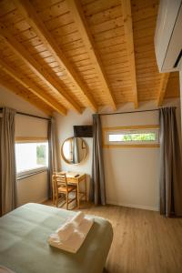 a bedroom with a bed and a table with a chair at Casa dos Gatos in Lourinhã