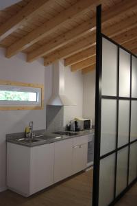 a kitchen with white cabinets and a sink and a window at Casa dos Gatos in Lourinhã