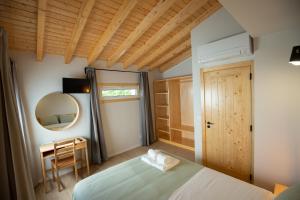 une chambre avec un lit, un bureau et un miroir dans l'établissement Casa dos Gatos, à Lourinhã