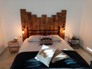 Schlafzimmer mit einem großen Bett mit einem Kopfteil aus Holz in der Unterkunft La Gurlanne in Lasséran