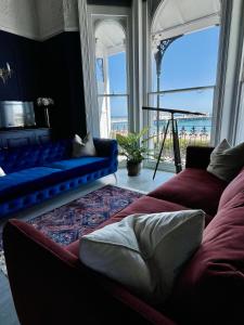 una sala de estar con sofás y vistas al océano. en The Regency Studio - Stunning Seaview en Worthing