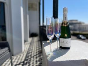 a bottle of wine and two wine glasses on a table at The Regency Studio - Stunning Seaview in Worthing