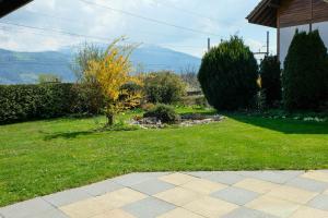 a yard with green grass and trees and a house at Luna in Thun