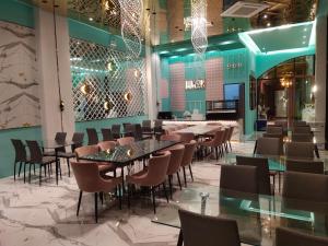 S3 Huahin Hotel في هوا هين: غرفة طعام مع طاولات وكراسي وأضواء