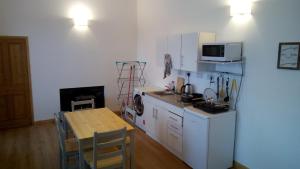 a kitchen with a refrigerator and a table and a microwave at The Uyeasound Old Pier Cottage in Belmont