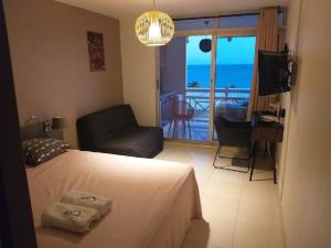 una camera con letto e un soggiorno con balcone di Superbe studio Mi Amor face au Rocher du Diamant a Le Diamant