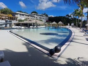 una piscina in un resort con persone di Superbe studio Mi Amor face au Rocher du Diamant a Le Diamant