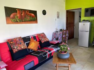 ein Wohnzimmer mit einem Sofa und einem Tisch in der Unterkunft Villa Prunepassion in Le Moule