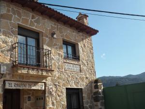 a stone building with two windows and a sign on it at El Rincón de Anter in Higuera de las Dueñas