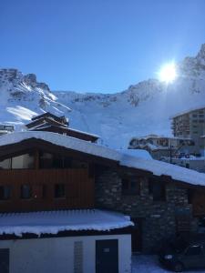 ein Gebäude mit Schnee auf dem Dach mit einem Berg in der Unterkunft Studio 1 cabine chalet club III refait à neuf in Tignes