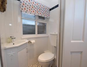 une salle de bain avec toilettes, lavabo et fenêtre dans l'établissement 4 Landgate Cottages, à Winchelsea 27 autres photos