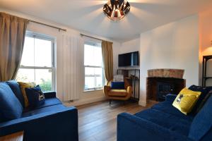 - un salon avec deux canapés bleus et une cheminée dans l'établissement 4 Landgate Cottages, à Winchelsea