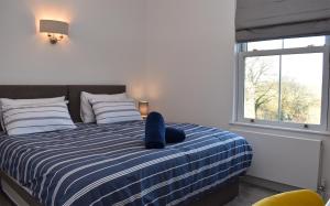 une chambre avec un lit avec un oreiller bleu dessus dans l'établissement 4 Landgate Cottages, à Winchelsea