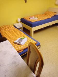 a room with two beds and a table and a chair at Kleines Appartment zentrale Lage in Künzell